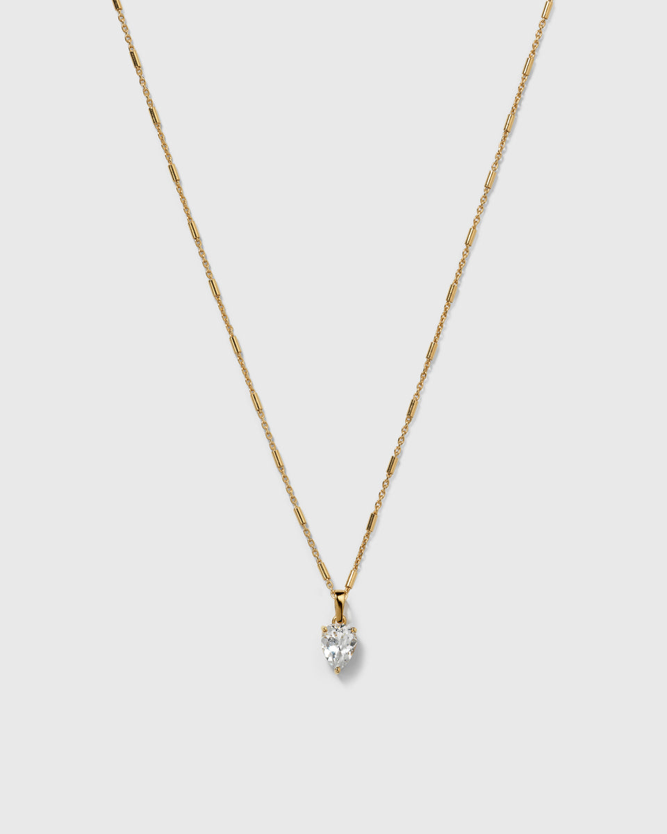 A product shot of the Katie Necklace in gold, featuring its unique chain with bar-like links and a drop-shaped pendant with a set cubic zirconia stone.