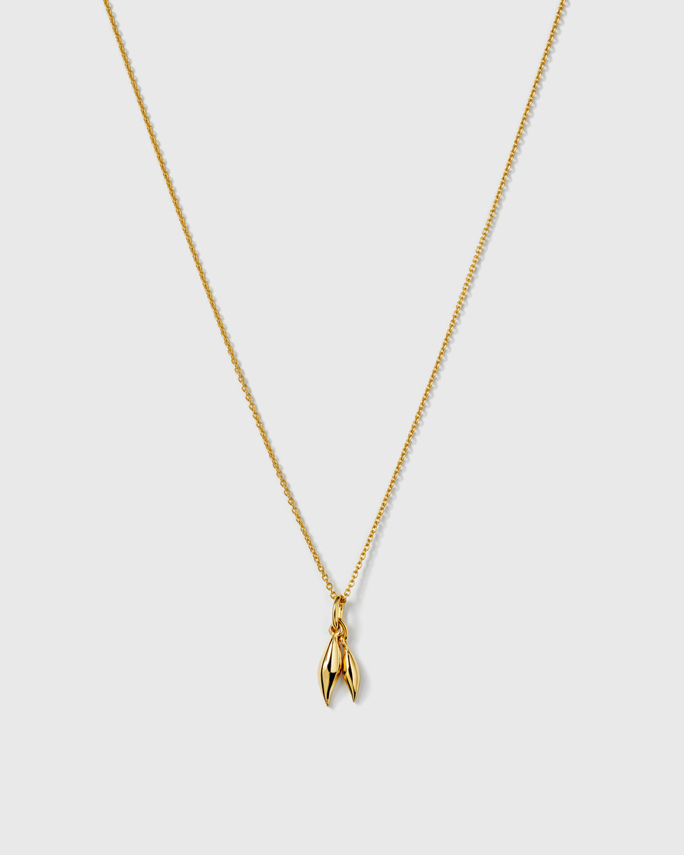 A product shot of the Melinda Double Petal Necklace in gold, featuring a delicate chain and a pendant composed of two small, polished leaves.