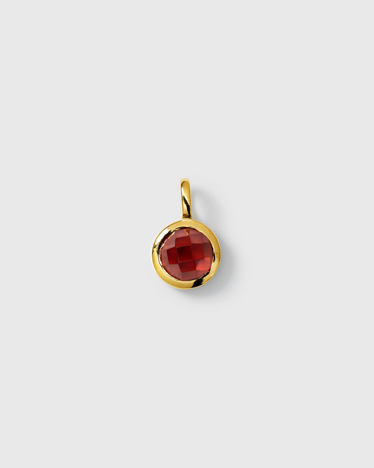January birthstone gold pendant with round faceted red garnet.