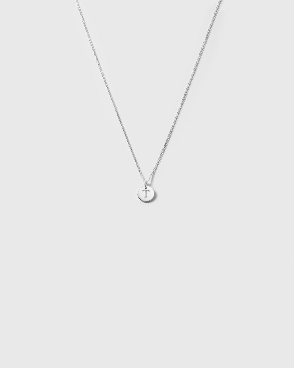 A product shot of the Beloved Short Oval Chain in silver, styled with a small, round pendant engraved with the letter 'T'.