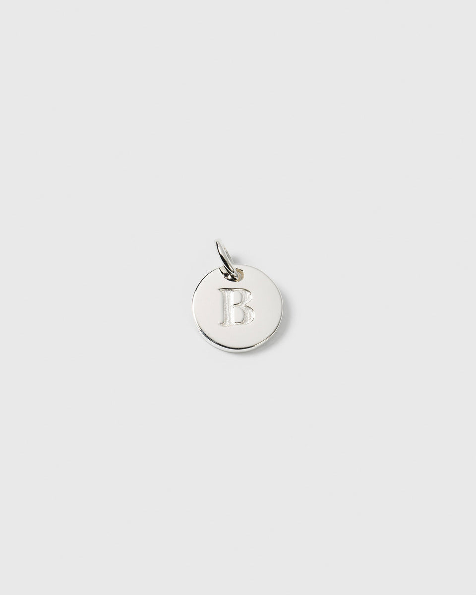 A product shot of the Syster P Beloved Mini Letter charm in silver, featuring the letter 'B' engraved on its small, round surface.