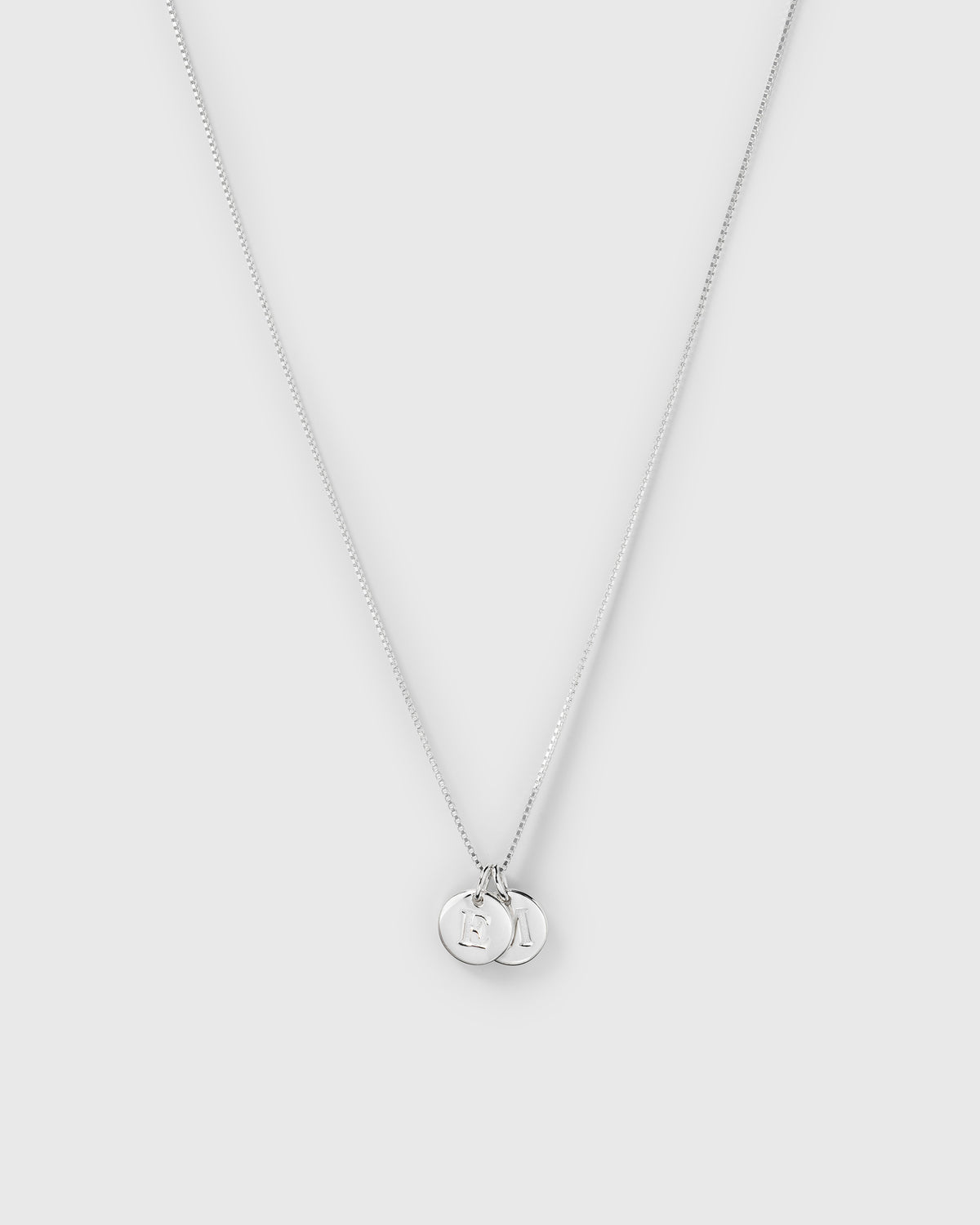 A product shot of the Beloved Medium Box Chain in silver, adorned with two silver Beloved Mini Letter pendants.