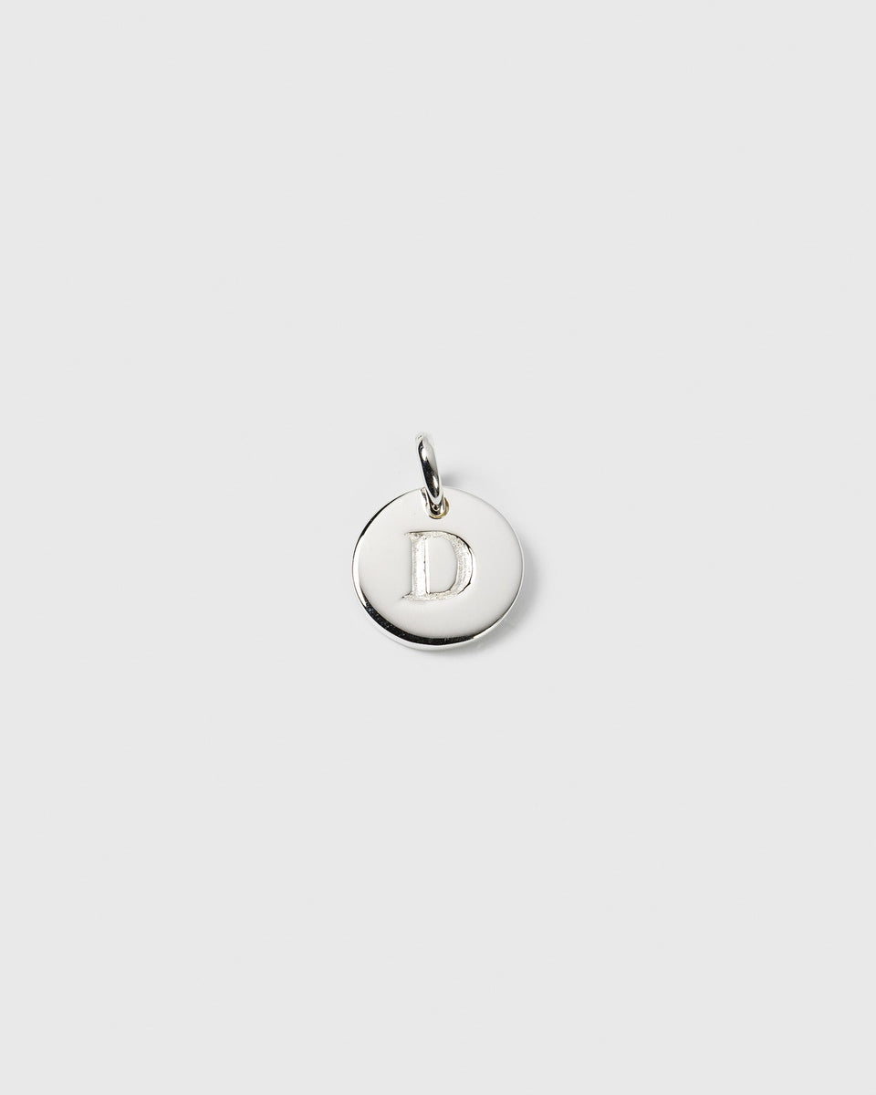 A product shot of the Beloved Mini Letter charm in silver, showcasing the round pendant with the letter D engraved on it.