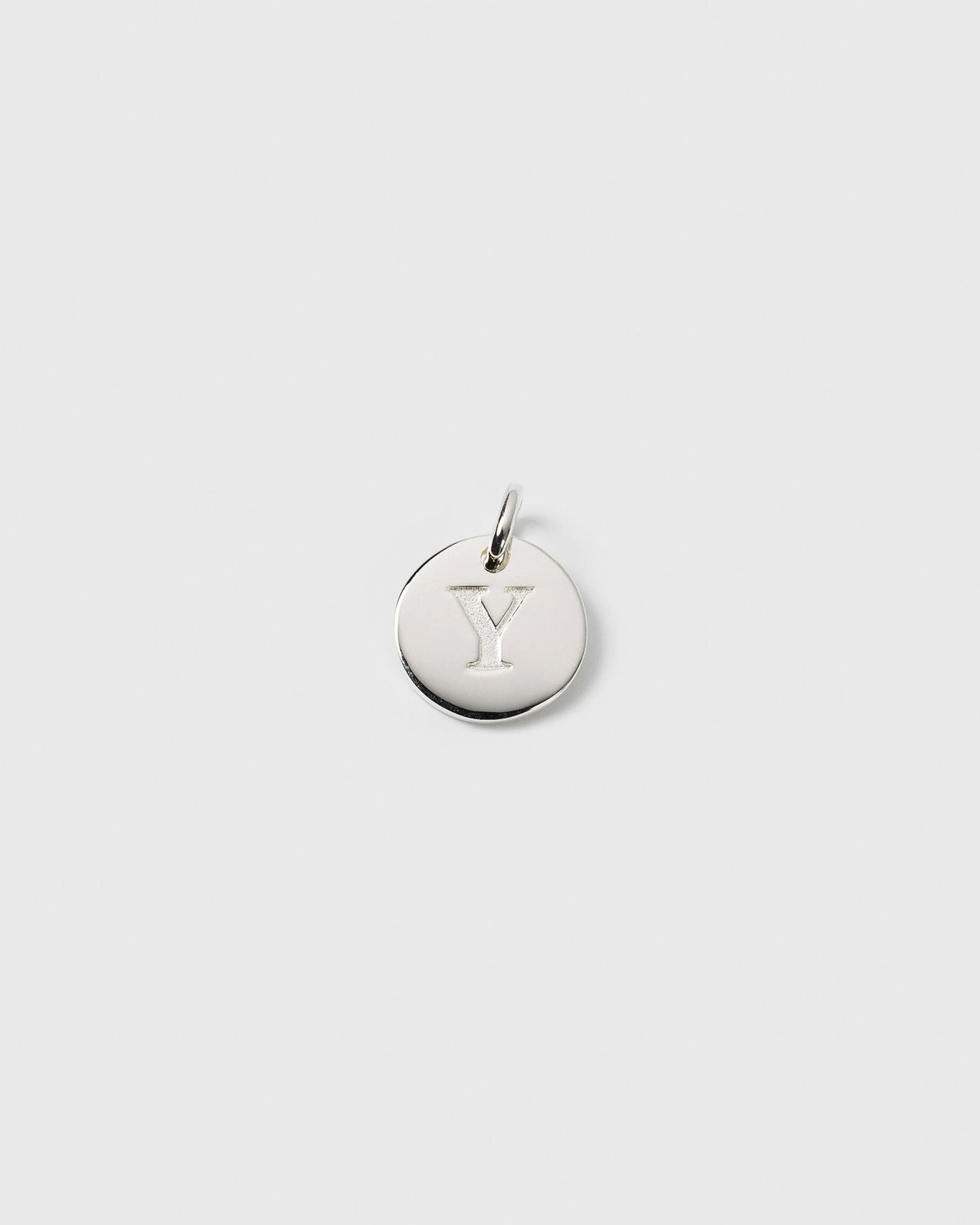 A product shot of the Beloved Mini Letter Silver charm, a round pendant with the letter 'Y' engraved in the center.