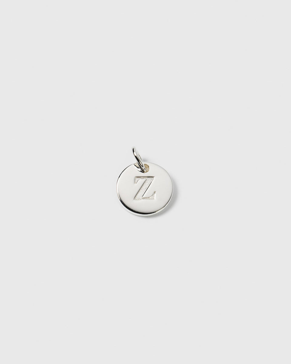 A product shot of the Beloved Mini Letter Silver charm, a small round pendant engraved with the letter Z.