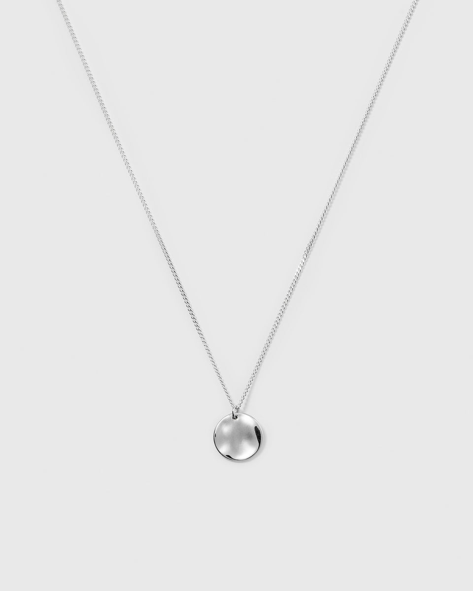 A product shot of the Minimalistica Hammered Necklace in silver, featuring a fine chain and a round pendant with a hammered surface.