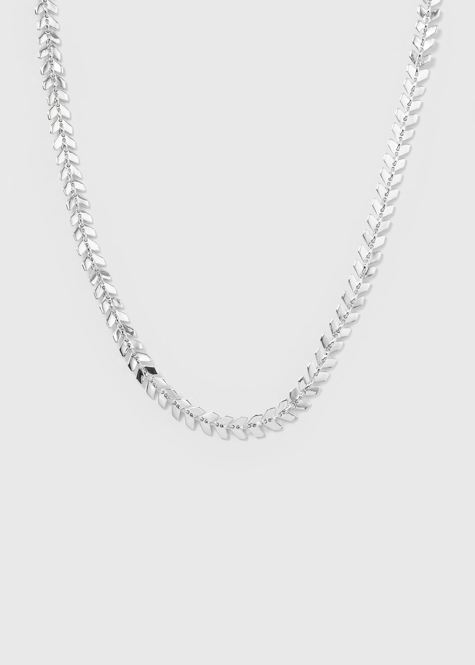 A product shot of the Layers Olivia Necklace in silver, displayed in a curve to showcase its design of small, interconnected leaf-like parts.