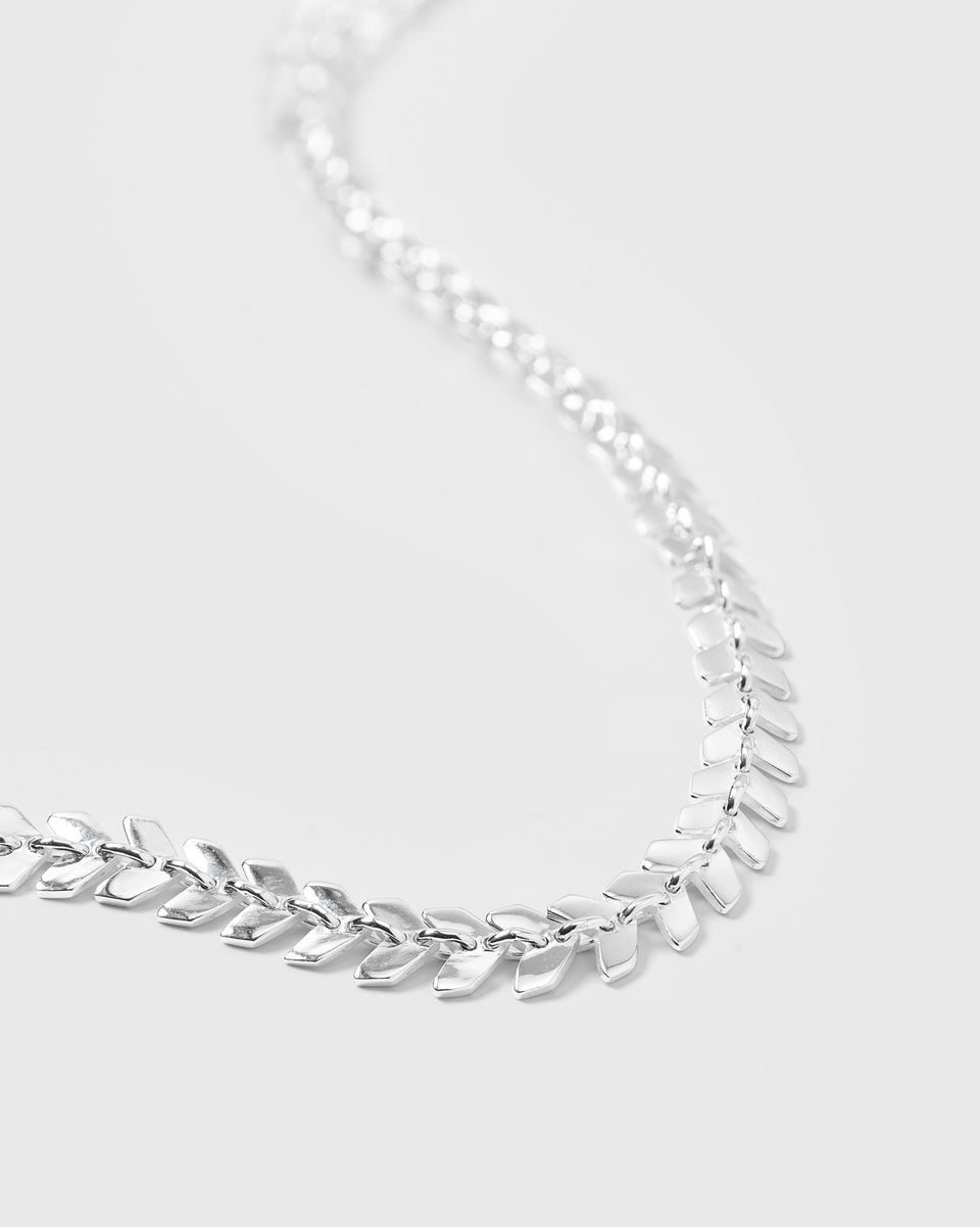A close-up product shot of the Layers Olivia Necklace in silver, showcasing the detailed design of its chain composed of small, leaf-like links.