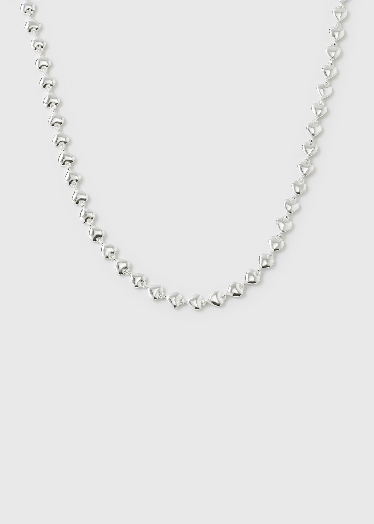 A product shot of the Darling Necklace in silver, displaying its chain made of small, interconnected hearts.