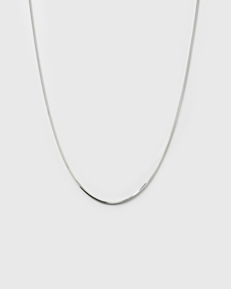 A product shot of the Sheer Mirror Necklace in silver, showcasing its smooth and flat chain design.
