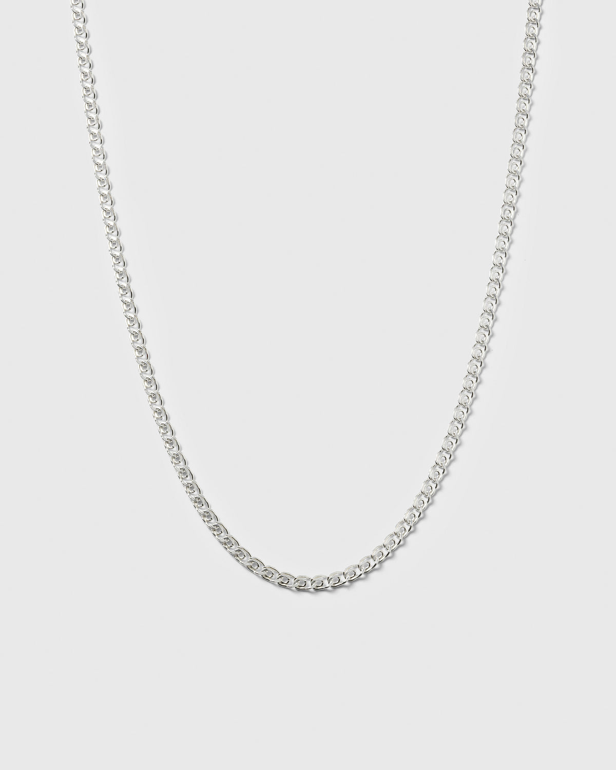 A product shot of the Sheer Love Necklace in silver, displayed in a U-shape to highlight its uniquely patterned links.