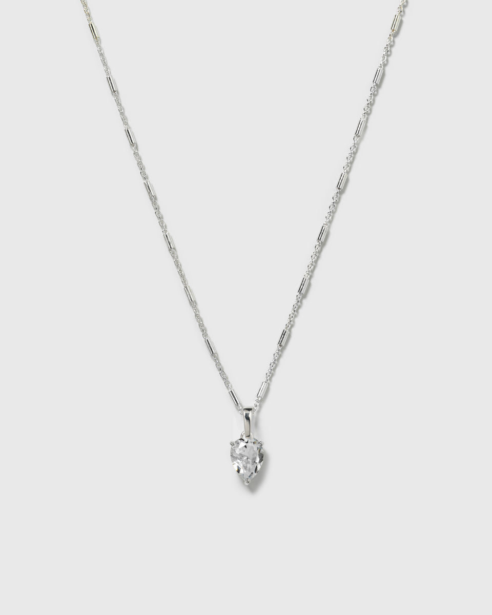 A product shot of the Katie Necklace in silver, featuring its unique chain with small bar details and a heart-shaped cubic zirconia pendant.