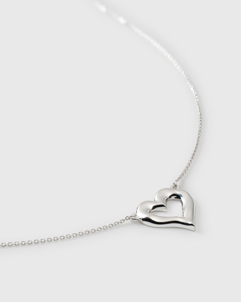 A close-up product shot of the Puff Heart Necklace in silver, focusing on the chunky, organic-shaped heart pendant and the fine chain.