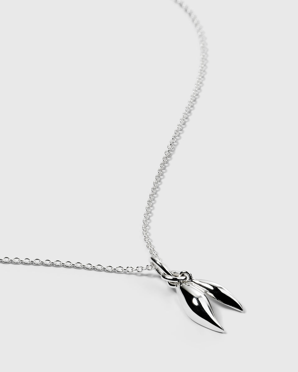 A product shot of the Melinda Double Petal Necklace in silver, featuring its delicate chain and a pendant composed of two small, polished petals.
