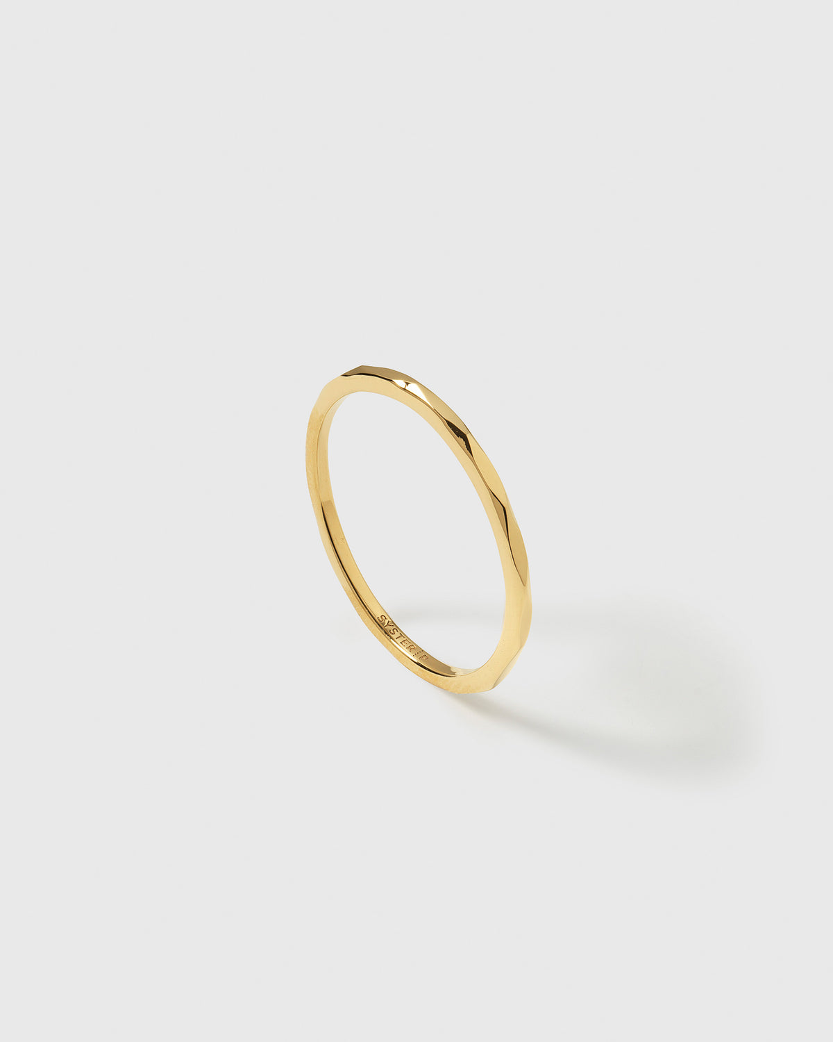 A product shot of the Tiny Ultrathin Ring in gold, showcasing its delicate design and slightly structured surface.
