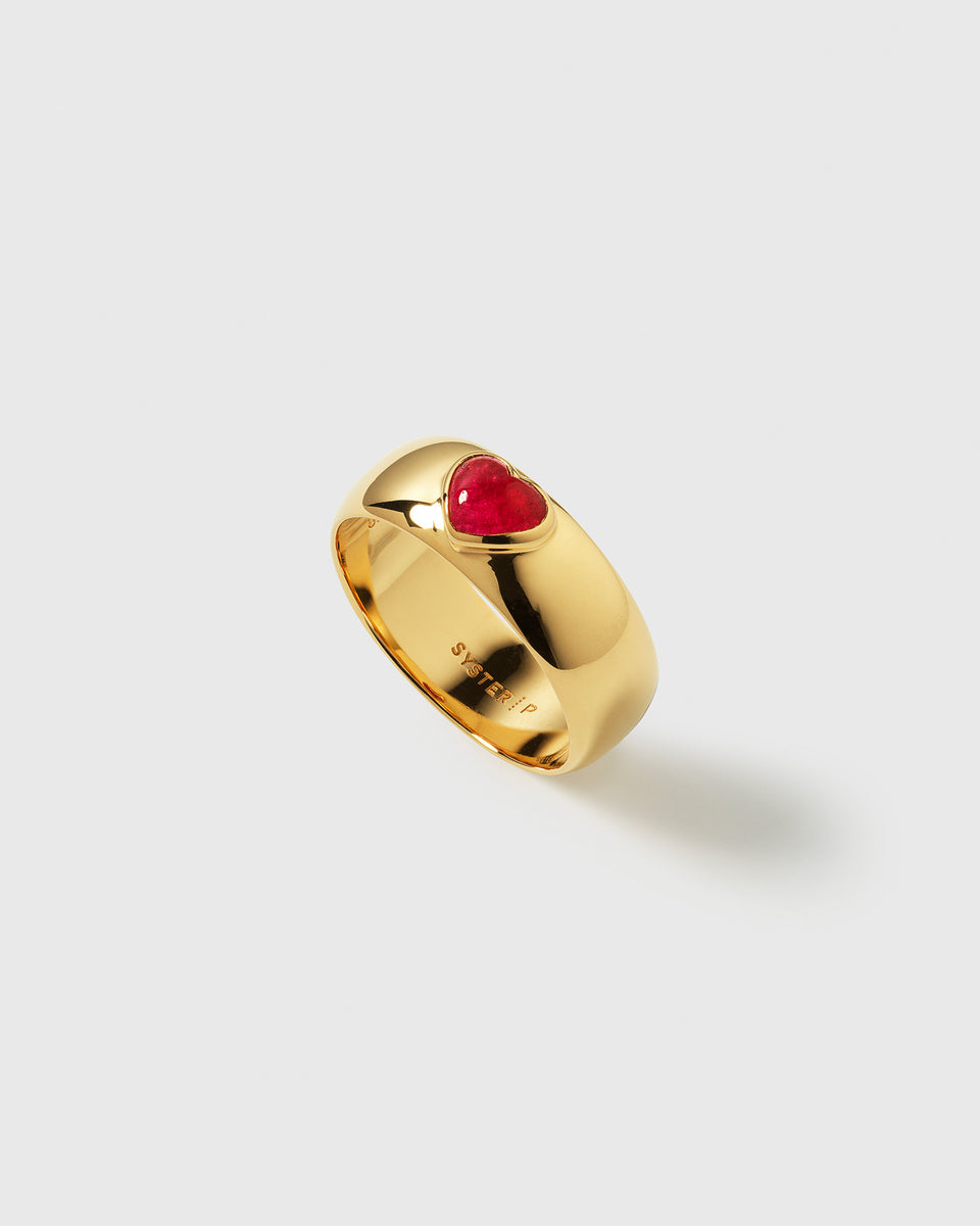 Close-up of the La La Love Ring, featuring a polished gold band set with a heart-shaped pink quartz stone.