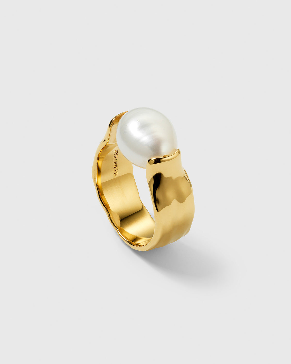 A close-up of the gold-plated Paxton ring, showing its hammered texture and the large, unique baroque freshwater pearl set on top.