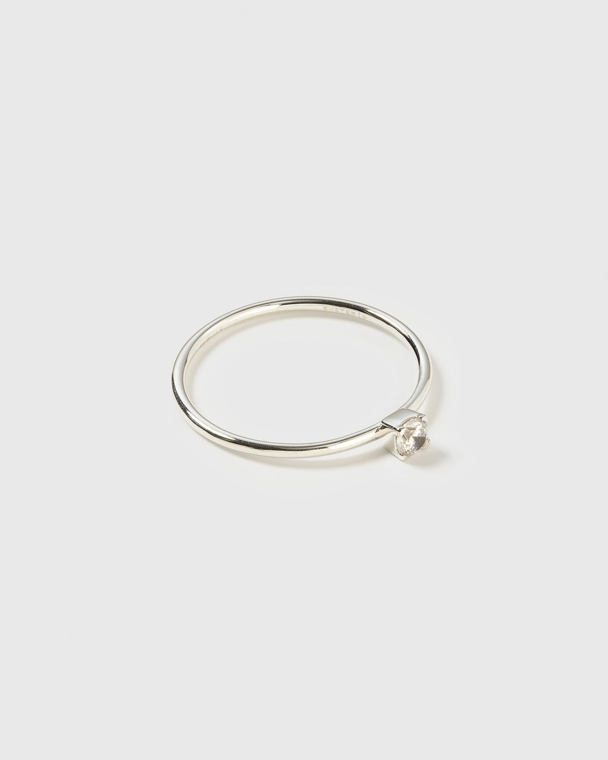 A product shot of the Tiny Princess Ring in silver, featuring a thin band with a single, round faceted crystal in a princess setting.
