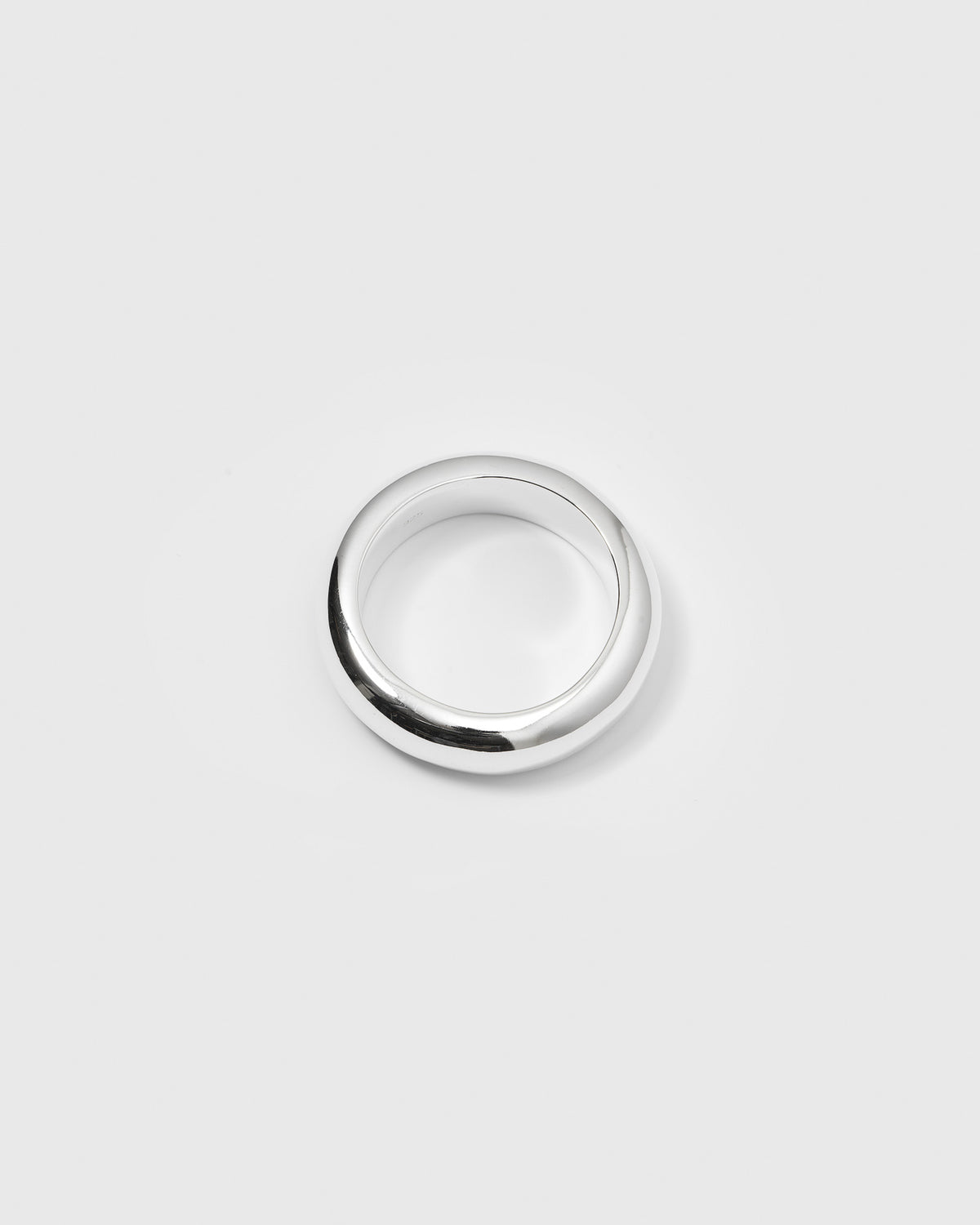 A product shot of the Bolded Ring in silver, showcasing its thick, rounded, and polished band design.