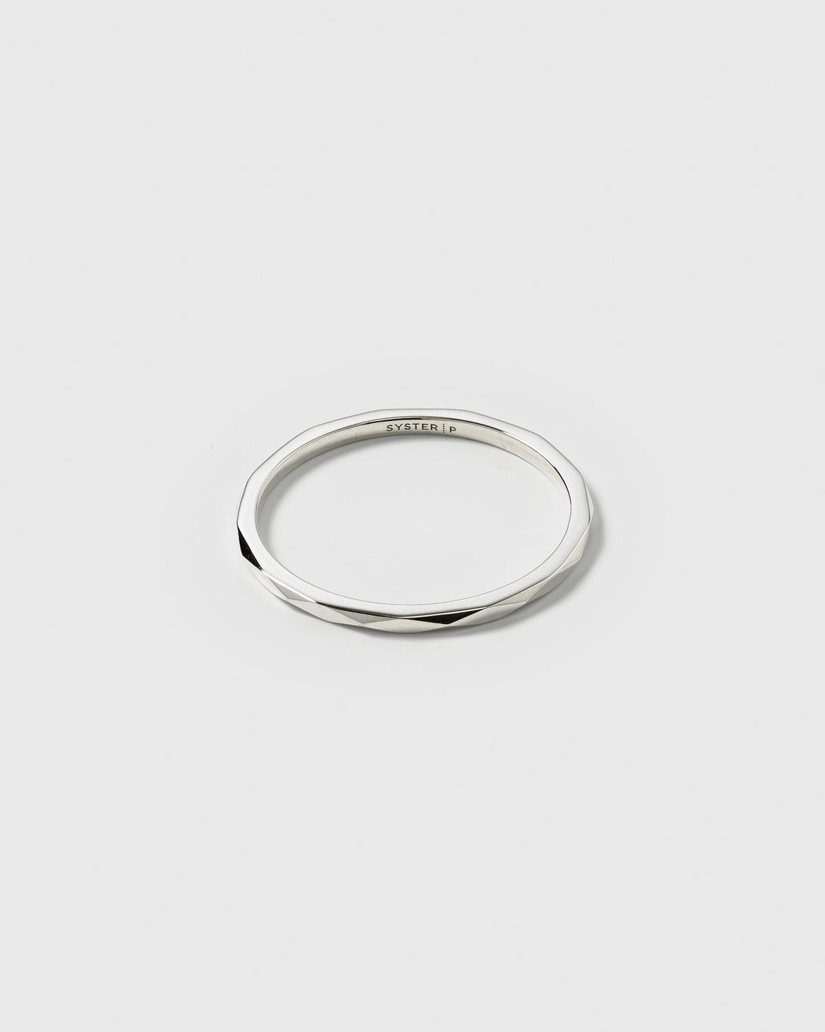 A product shot of the Tiny Ultrathin Ring in silver, showcasing its thin band with a faceted, structured surface.