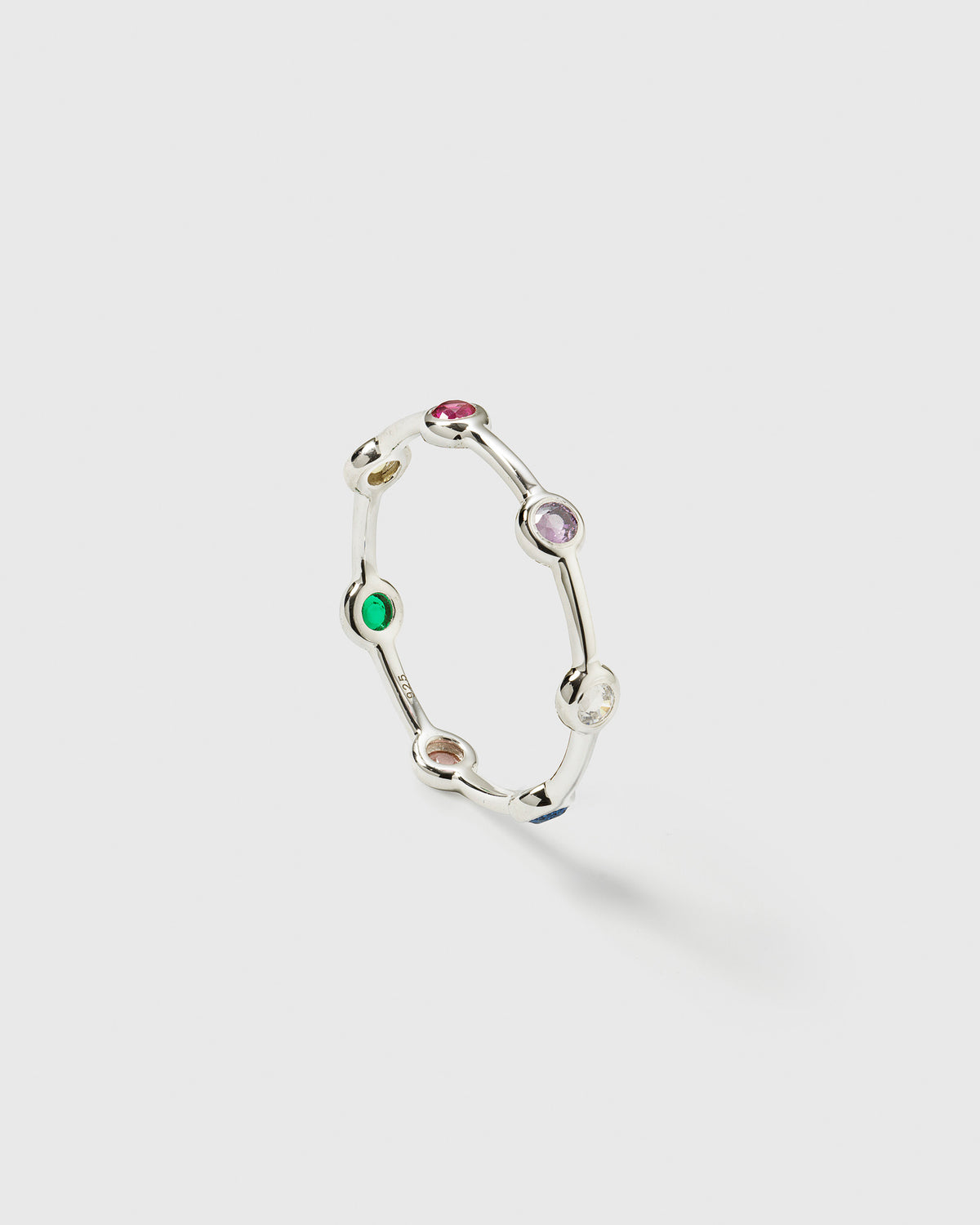 A product shot of the Treasure Shimmer Ring in silver, showing its design of a delicate band set with multi-coloured, round zirconias.