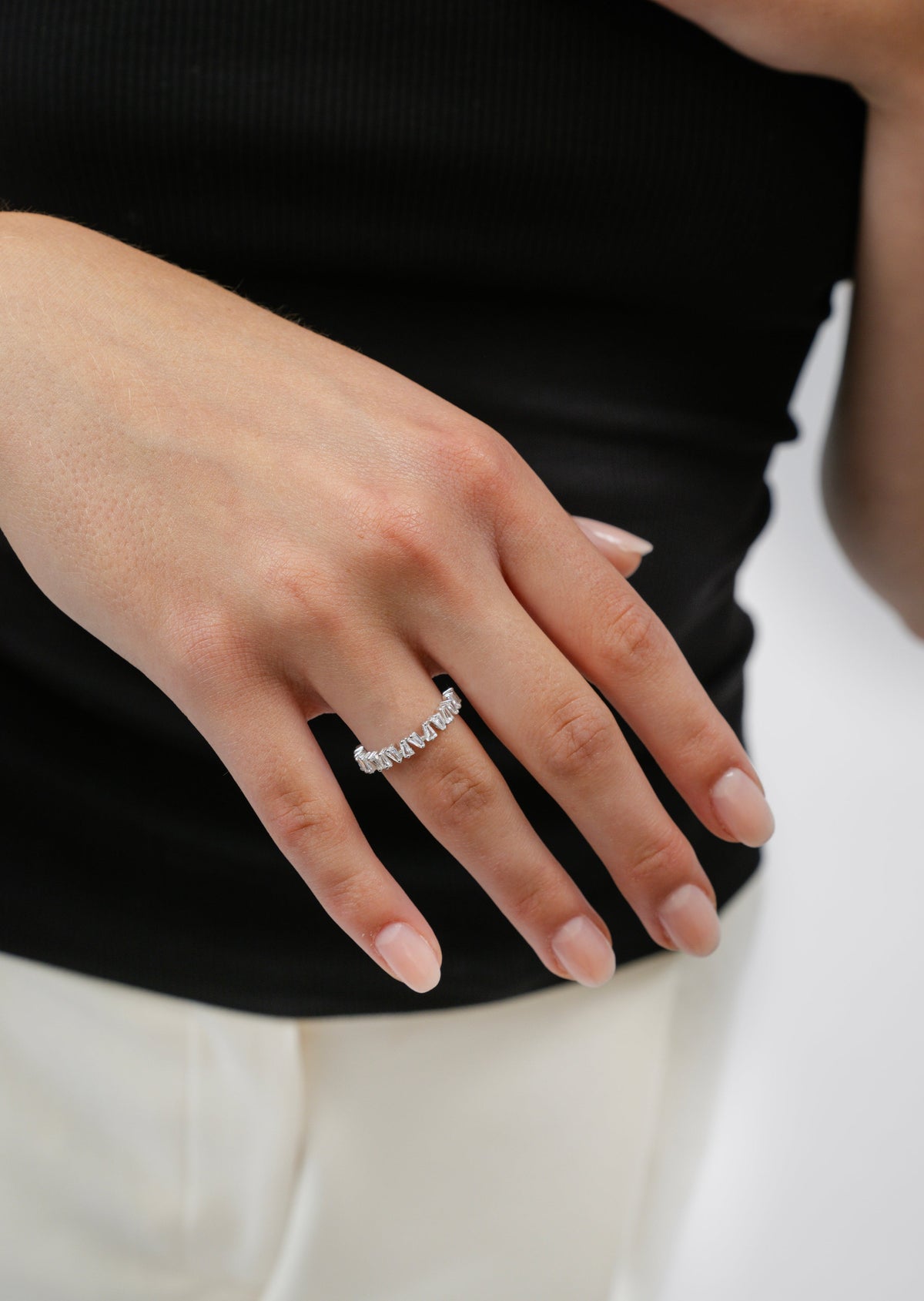 A close-up of a model wearing the Iggy Ring in silver, adorned with small, tapered baguette-cut cubic zirconias.