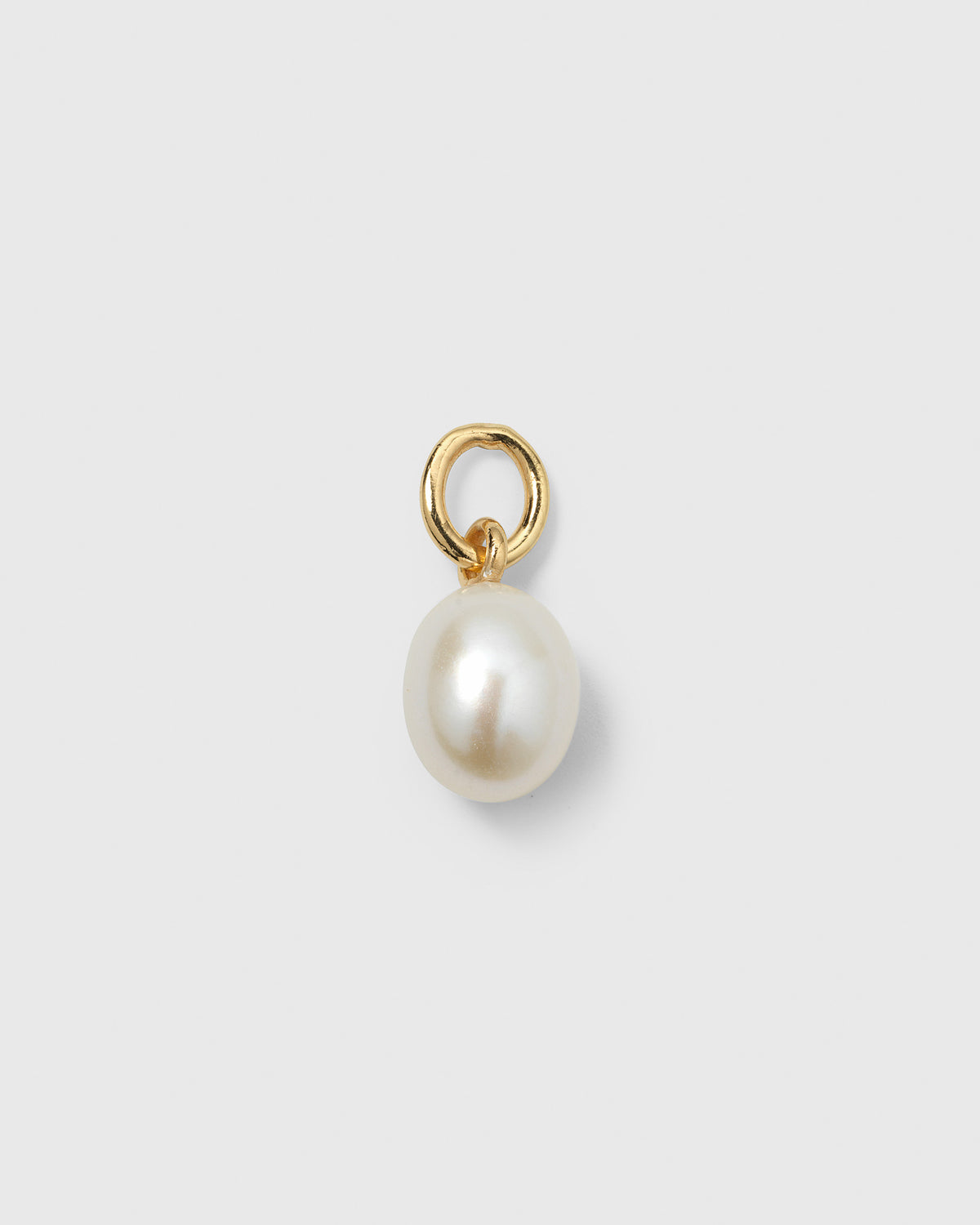 A product shot of the Beloved Pearl Pendant in gold, featuring a single freshwater pearl dangling from a small gold ring.