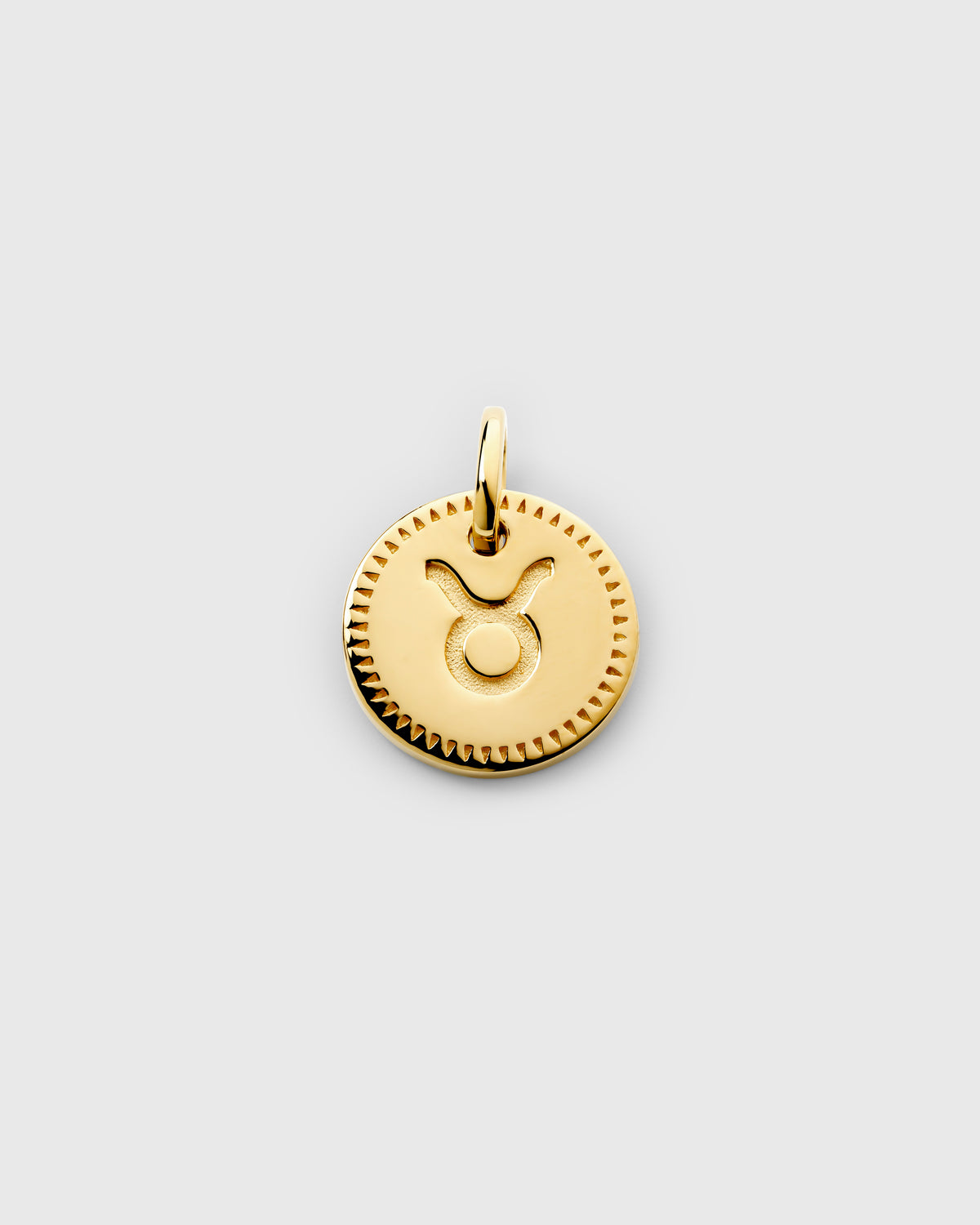 A product shot of the Beloved Zodie Pendant in gold for the star sign Taurus, featuring the engraved Taurus symbol on a round charm with a decorative border.