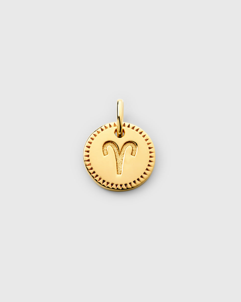 A product shot of the Beloved Zodie Pendant in gold, featuring the engraved zodiac symbol for Aries and a decorative border.