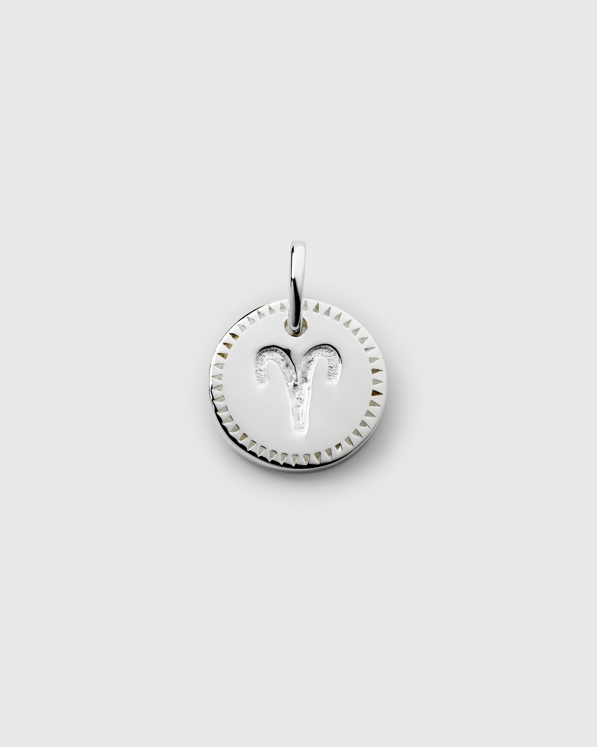 A product shot of the Beloved Zodie Pendant in silver, showcasing the Aries variant with its engraved zodiac symbol and a decorative triangular border.