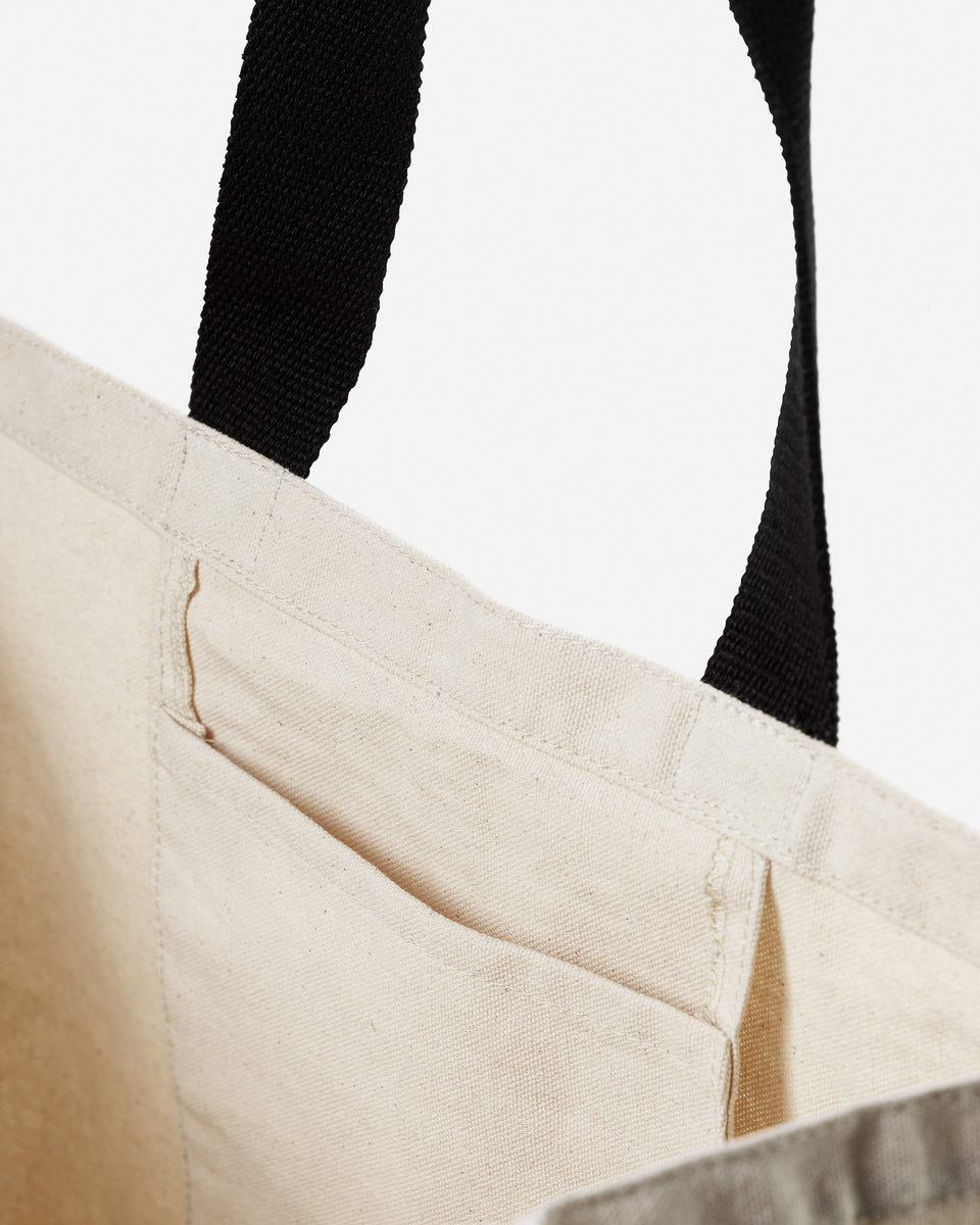 A close-up of the interior of the Syster P cotton tote bag, highlighting the handy inner pocket and the black handle.