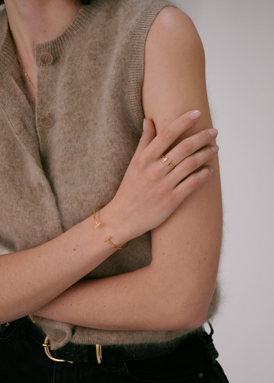 Gold bangle, paired with matching gold ring and thin gold necklace.