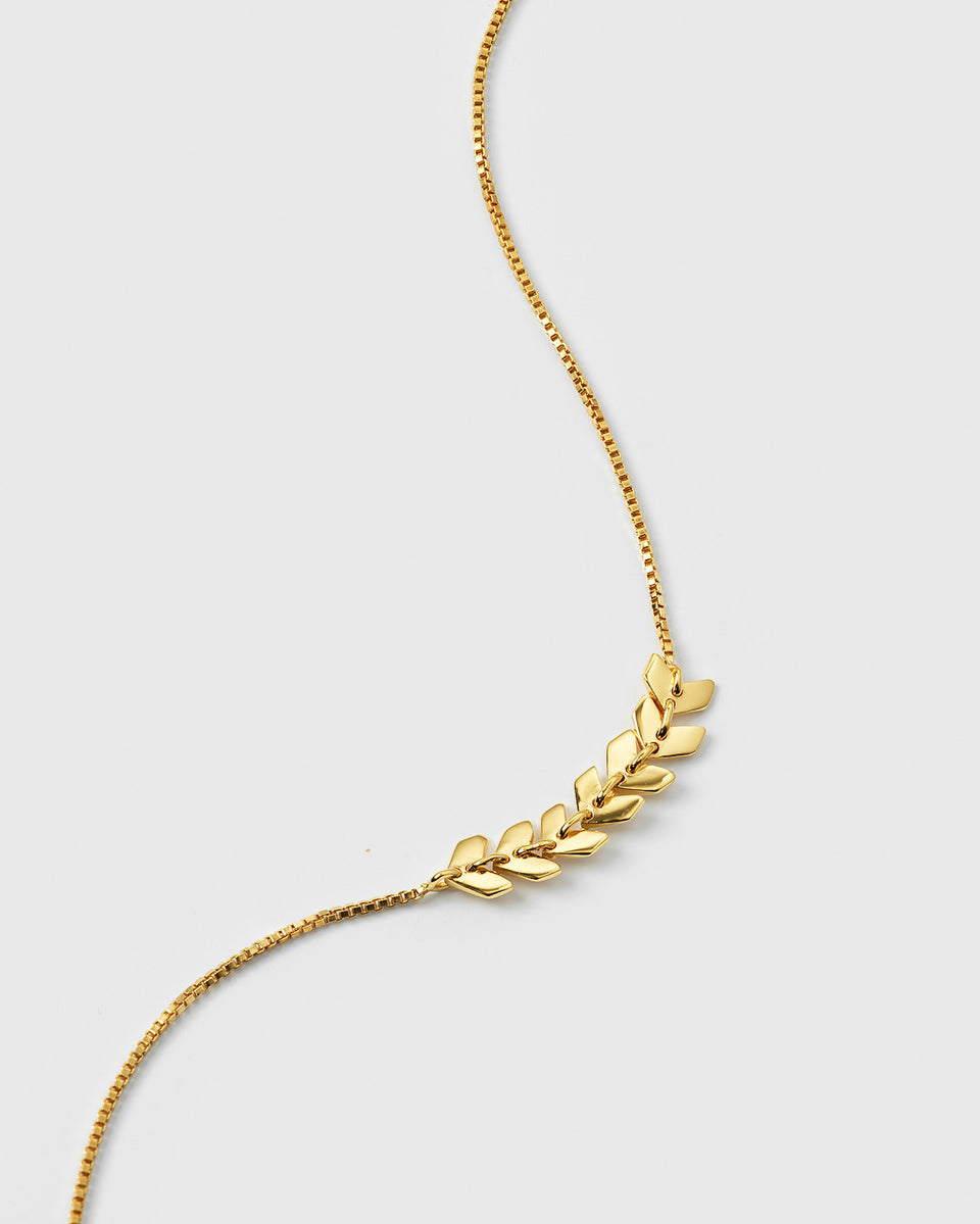 A close-up of the gold Layers Simone Bracelet, featuring a delicate box chain and a central pattern of small, shiny, leaf-like shapes.