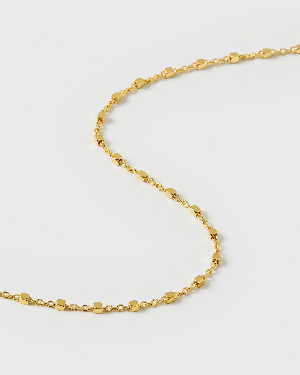 A close-up shot of the Sheer Station Bracelet in gold, showcasing its delicate station chain design with tiny, shining dots.
