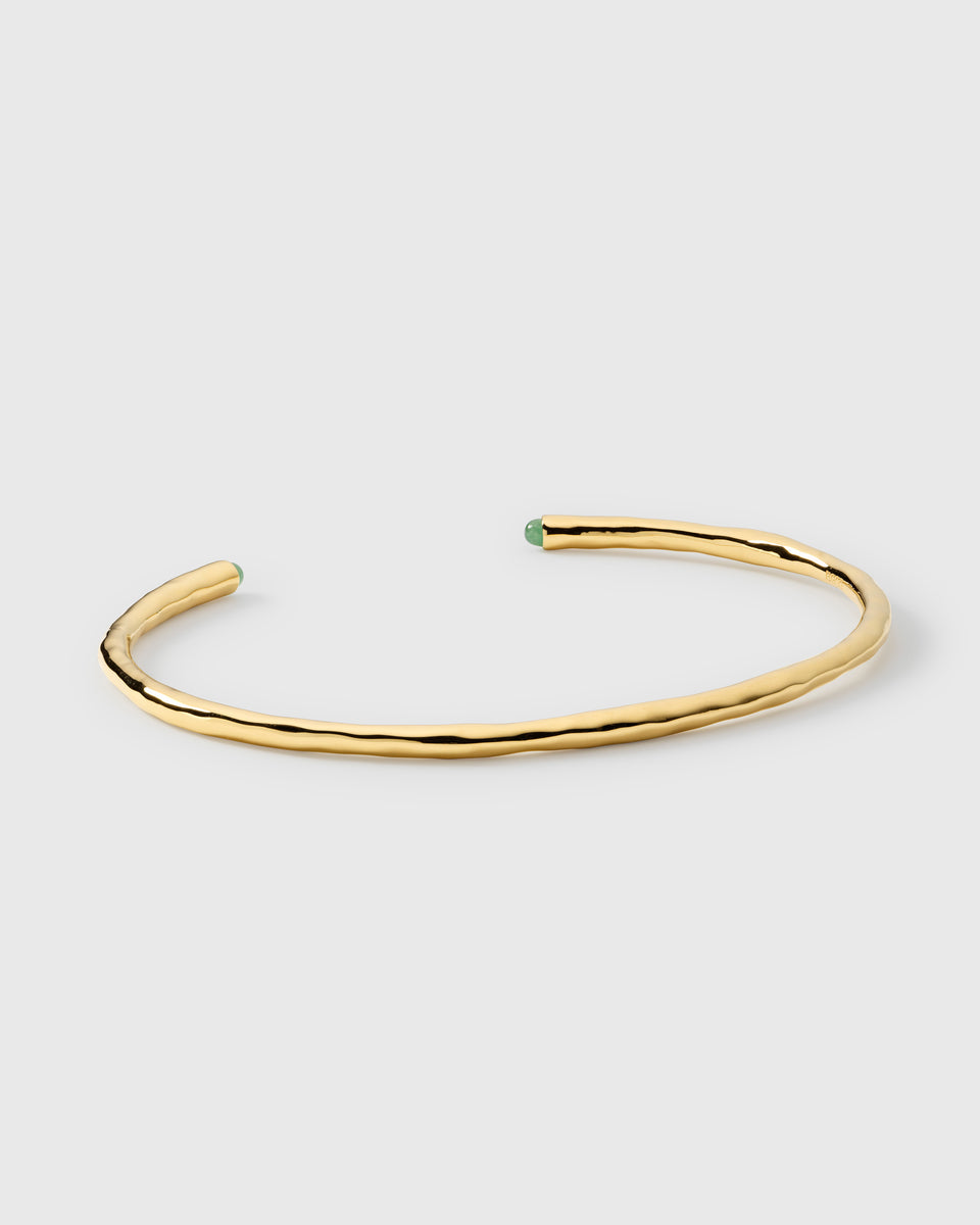 A product shot of the Florentina Bangle Gold Green Jade, an open cuff bracelet with a hammered gold surface and green jade stones at each end.