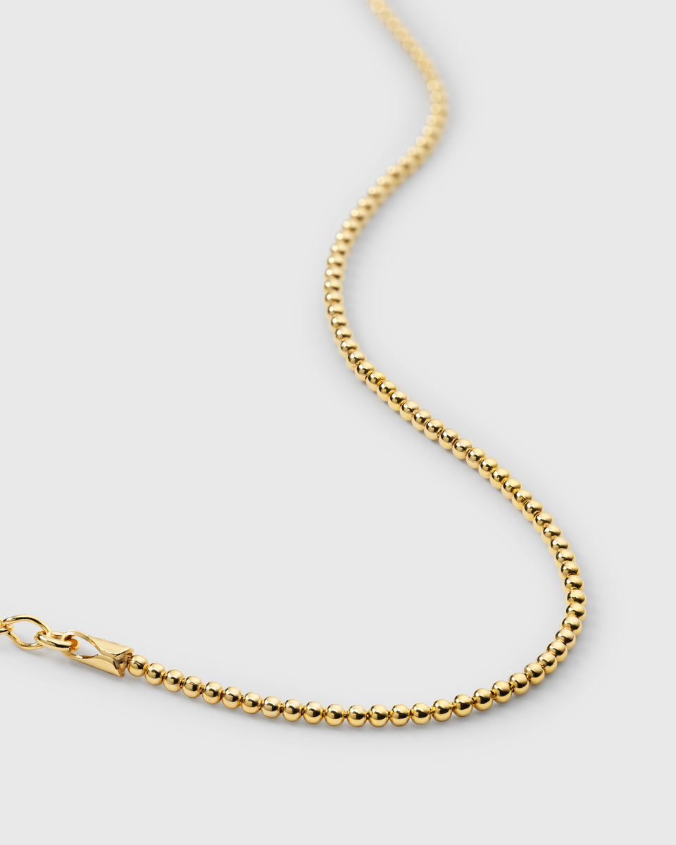 A delicate bracelet designed with a chain of small, polished gold beads.