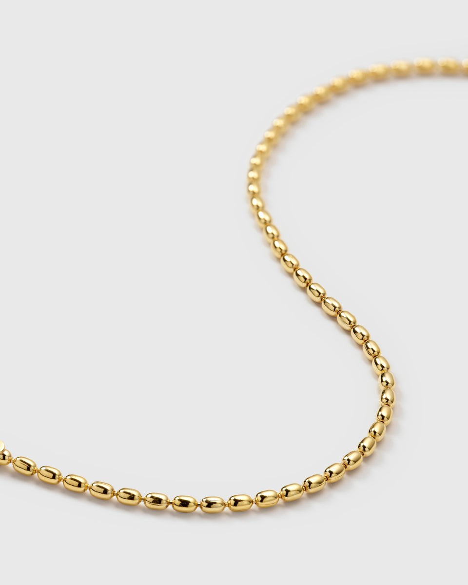 A close-up product shot of the Lunetta Bracelet in gold, showcasing its unique ball chain design composed of small, oval beads.