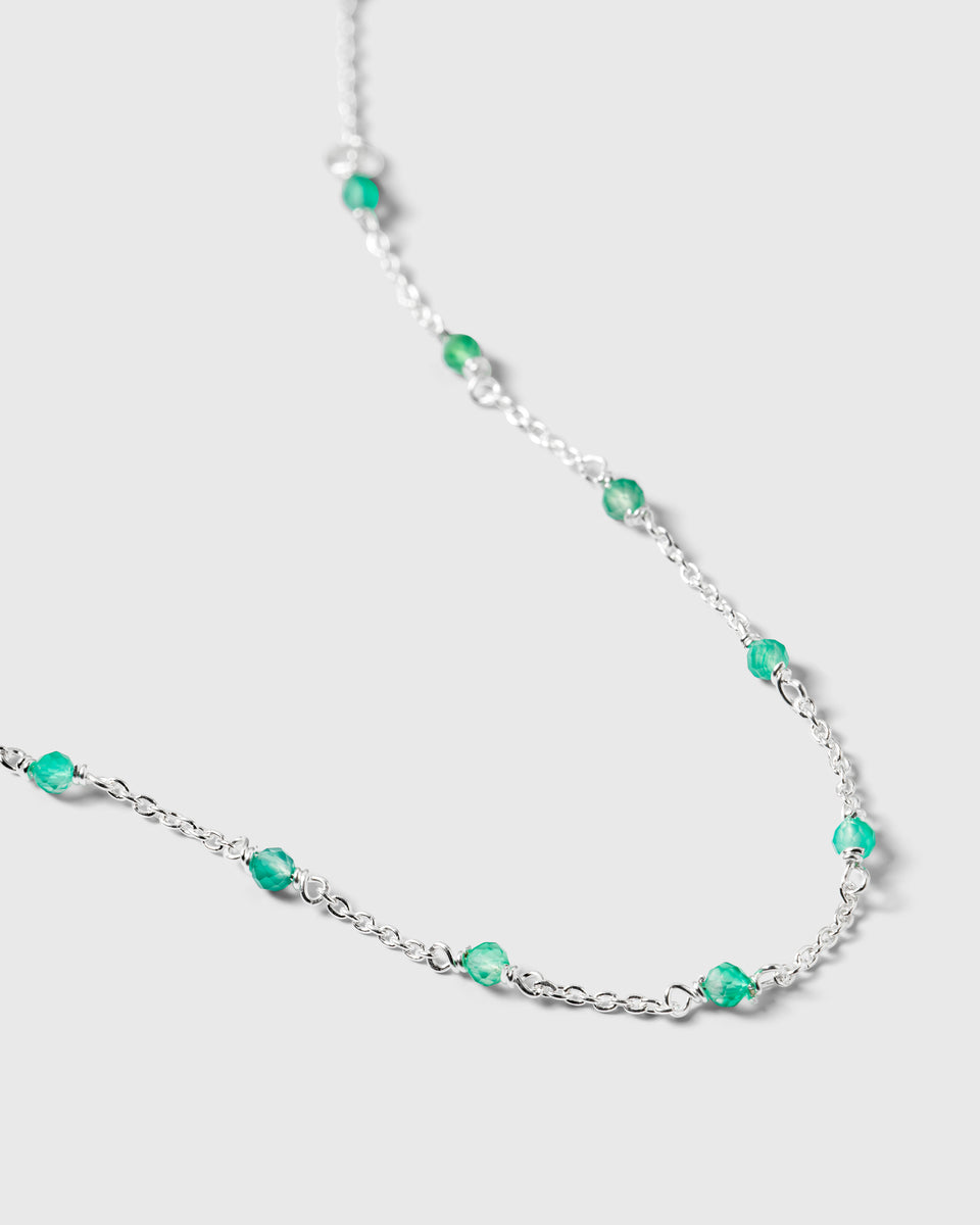 A close-up shot of the Santa Monica Bracelet in silver, highlighting its delicate chain design interspersed with small, faceted green onyx stones.