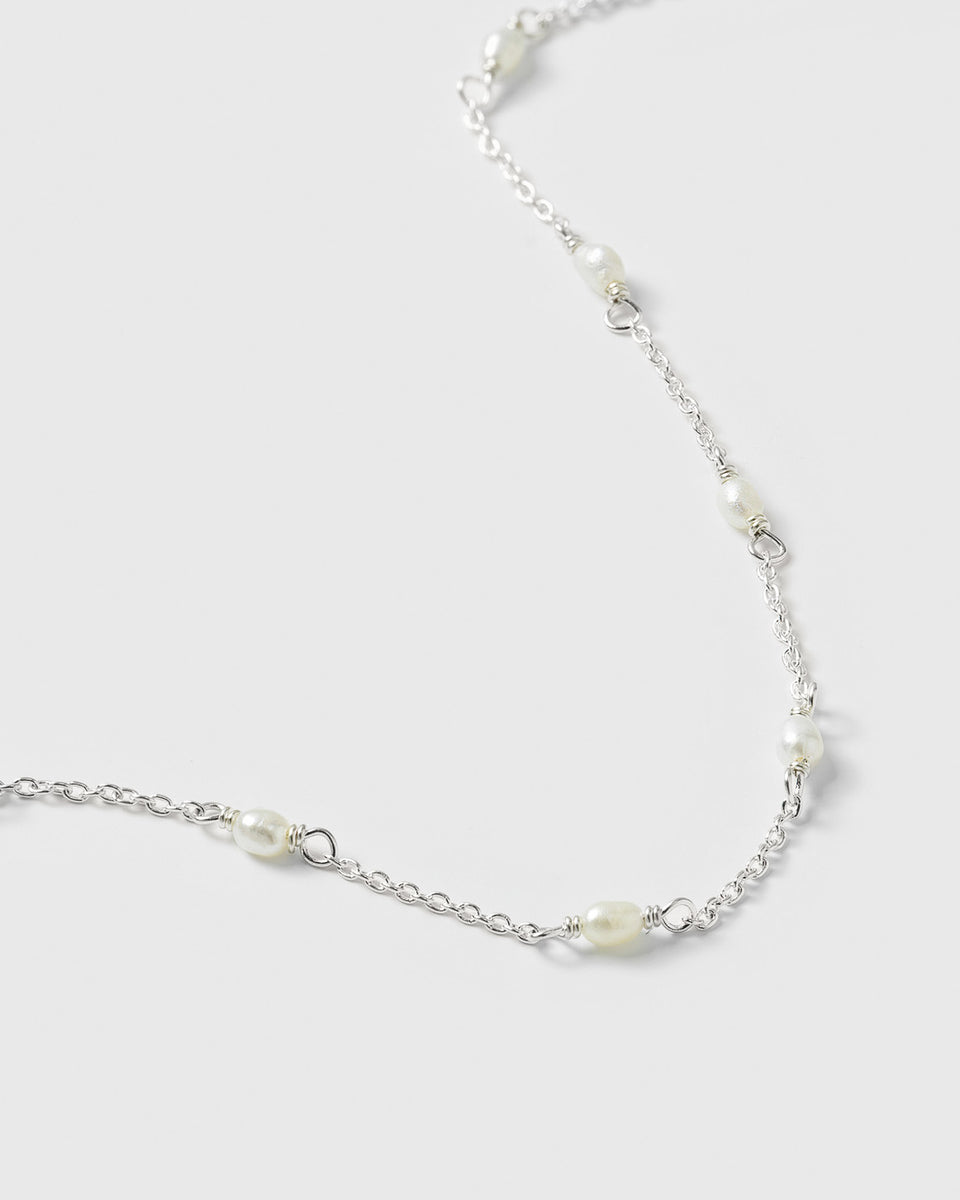 A close-up product shot of the Treasure Multi Pearl Bracelet in silver, highlighting its delicate chain design interspersed with small, oval freshwater pearls.