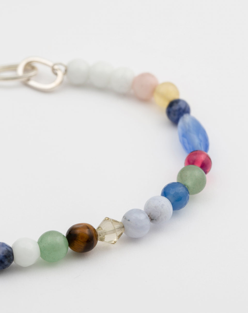 A close-up product shot of the Dream Catcher Bracelet in silver, highlighting its combination of multicolored natural stone beads in various shapes and sizes.