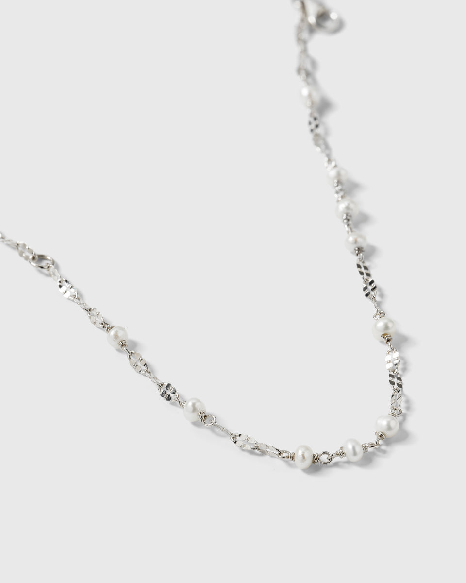 A close-up product shot of the Aurelia Bracelet in silver, highlighting its unique, light-catching chain interspersed with small freshwater pearls.