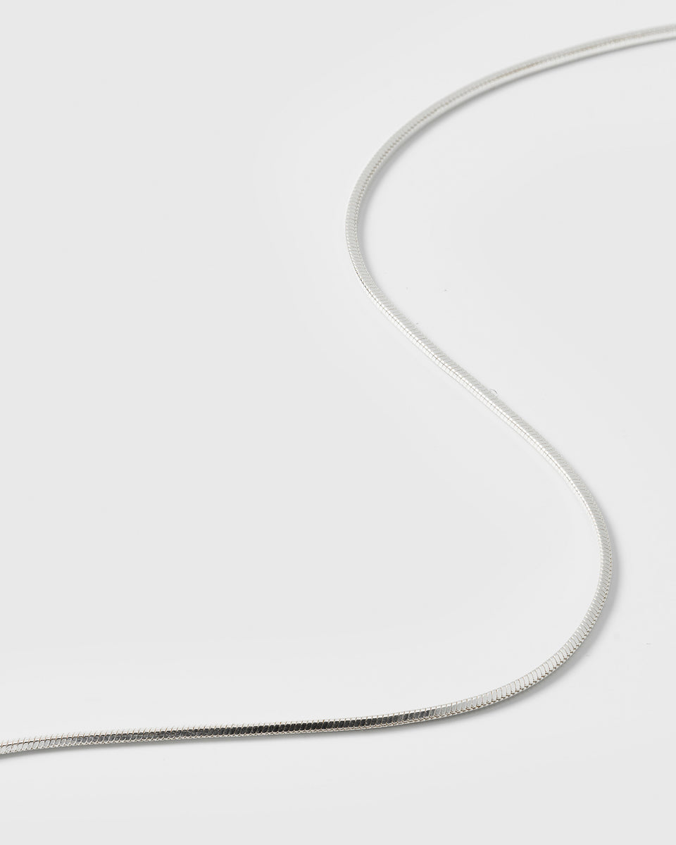 A close-up shot of the Sheer Mirror Bracelet in silver, highlighting its smooth and delicate flat snake chain design.