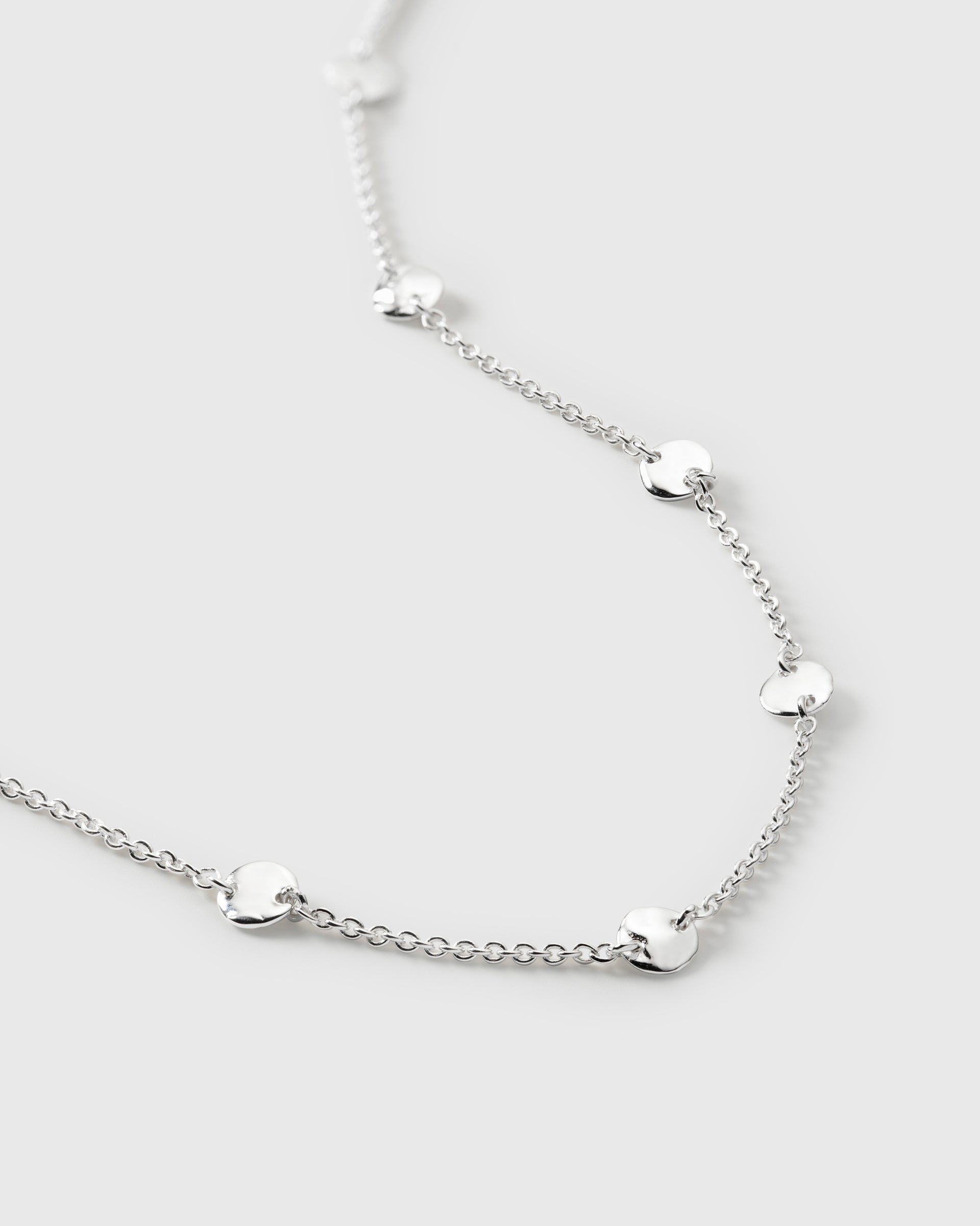 A close-up image of the Solea Bracelet in silver, showing the detail of its delicate chain and small, round, hammered circles.