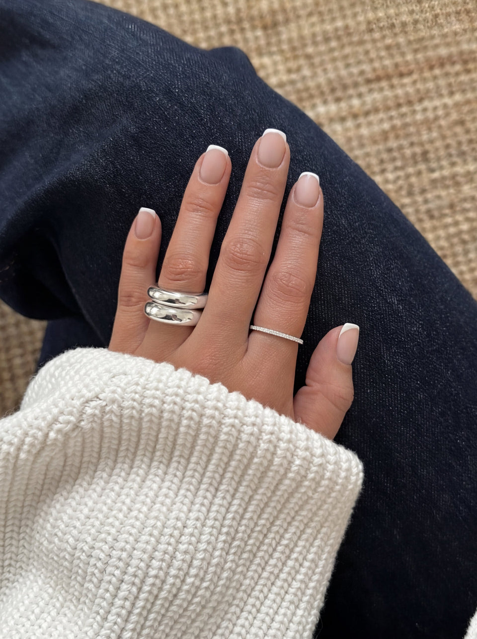 A close-up shot of a model wearing the Bolded Ring in silver, highlighting its substantial and rounded double-band design.