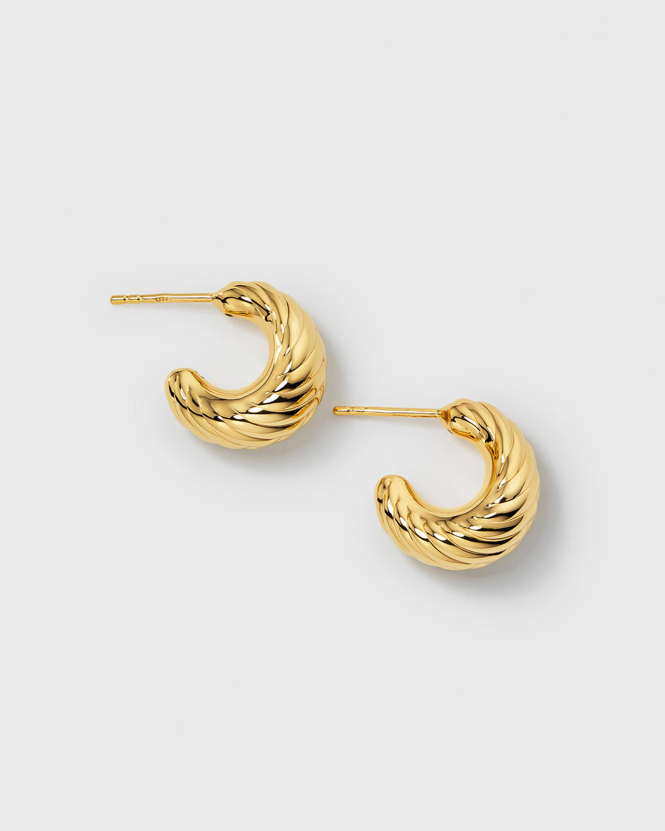 A product shot of the Bolded Little Sis Chevron Earrings in gold, laid out to showcase their chunky, twisted chevron design.