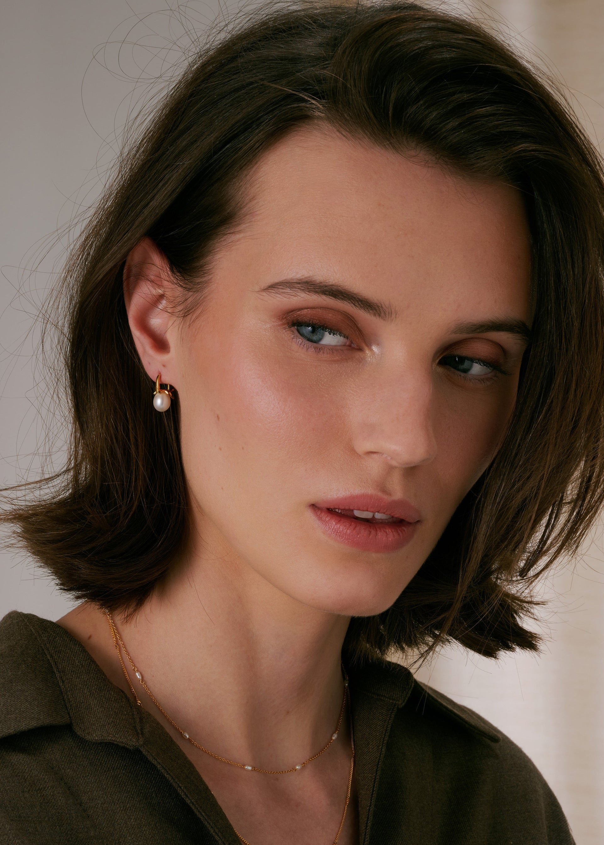 Small gold hoop with freshwater pearl pendant, paired with delicate gold chain necklace with small pearls.