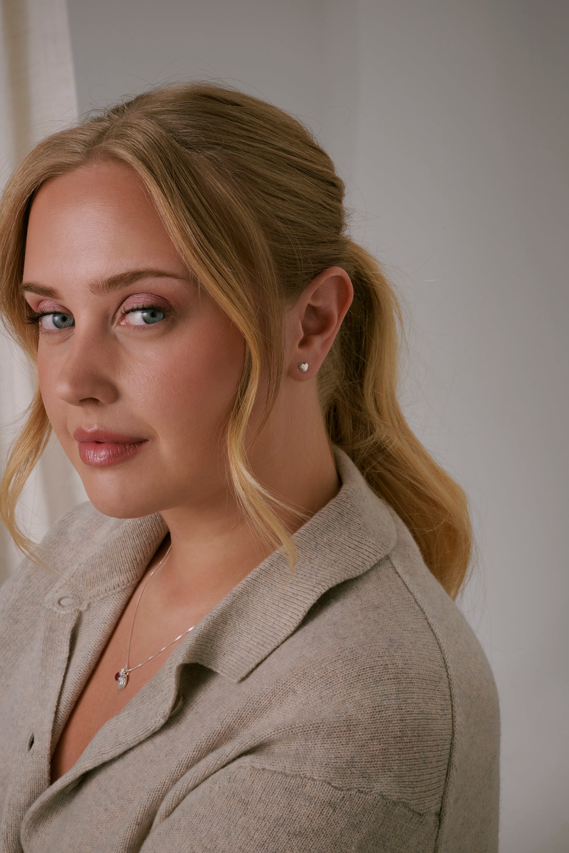 A shot of a model wearing the silver True Love Spike Heart Stud, an earring designed as a heart with small, edgy spikes.