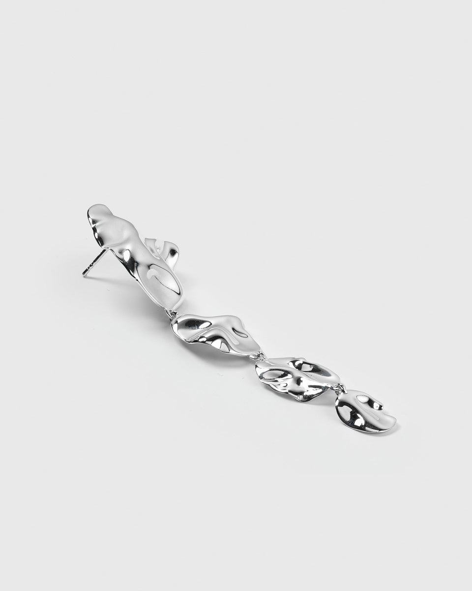 A product shot of the Moulded Long Single Earring in silver, highlighting its long, dangling form composed of several interconnected pieces with an organic, irregular surface.
