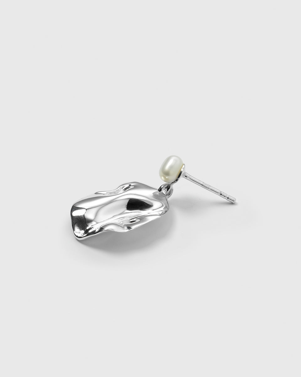 A product shot of the Moulded Short Single Earring in silver, featuring an organically shaped pendant with a moulded surface and a small freshwater pearl.