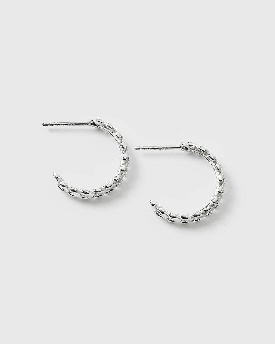 A product shot of the Layers Olivia Hoops in silver, showing their design of small, interconnected leaf-like parts.